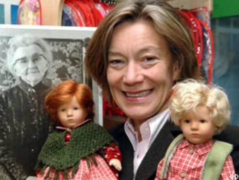 Die Geschaftsführerin der Kathe Kruse Puppen Andrea Kathrin Christenson steht mit zwei Puppen in der Fabrik in Donauwörth